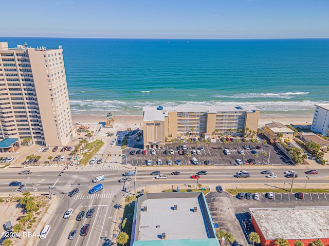 drone / aerial view featuring a water view and a view of the beach