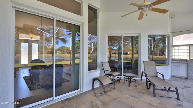 unfurnished sunroom featuring ceiling fan