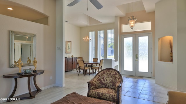 foyer entrance with french doors and ceiling fan with notable chandelier