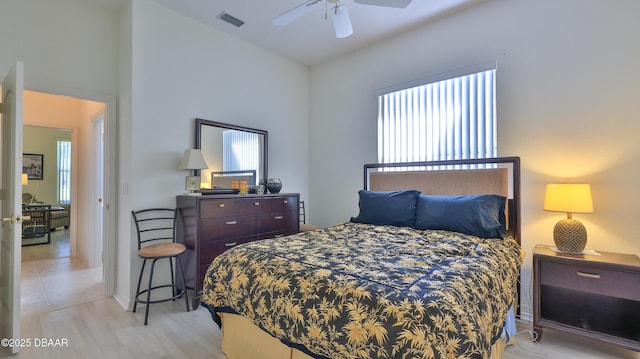 bedroom featuring ceiling fan, lofted ceiling, and light hardwood / wood-style flooring