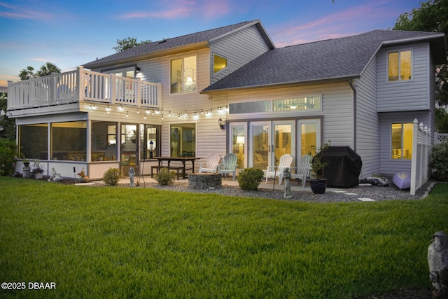 453 Palm Ave, Ormond Beach, FL 32174 - back of house at dusk with a patio, a yard, an outdoor fire pit, and a balcony
