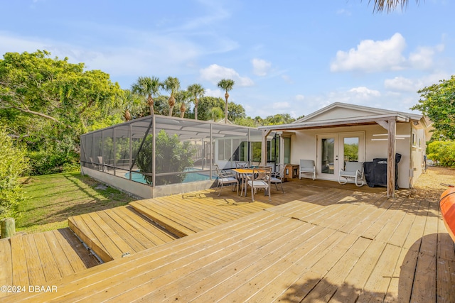 wooden terrace featuring french doors, a pool, and glass enclosure