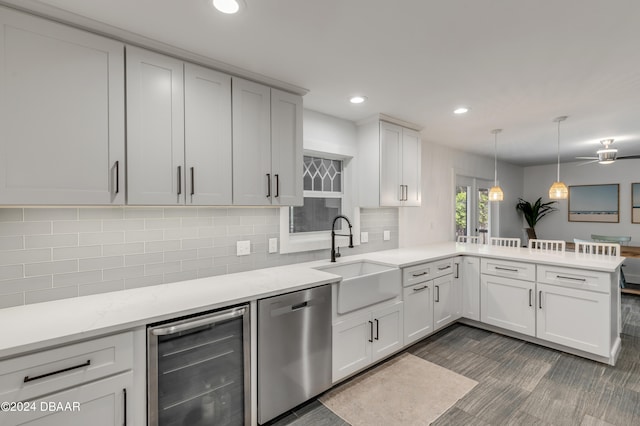 kitchen with kitchen peninsula, stainless steel dishwasher, beverage cooler, sink, and white cabinets