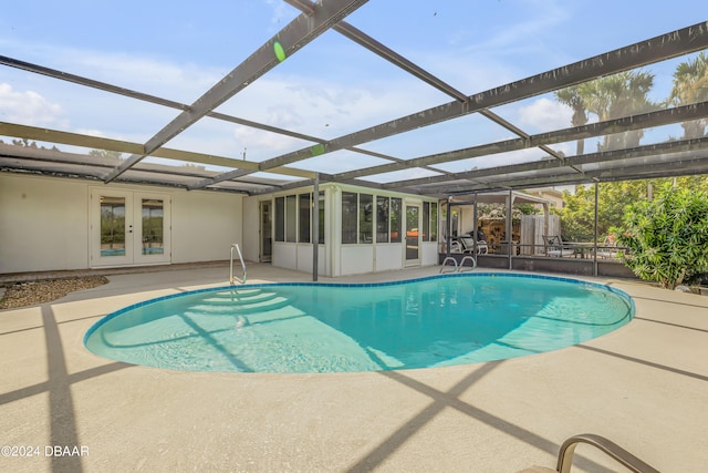 view of swimming pool featuring french doors, glass enclosure, and a patio area