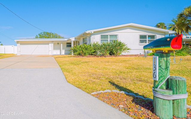 view of front facade with concrete driveway, an attached garage, fence, and a front lawn