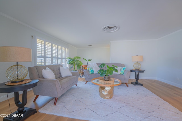 living room with light wood-type flooring and crown molding