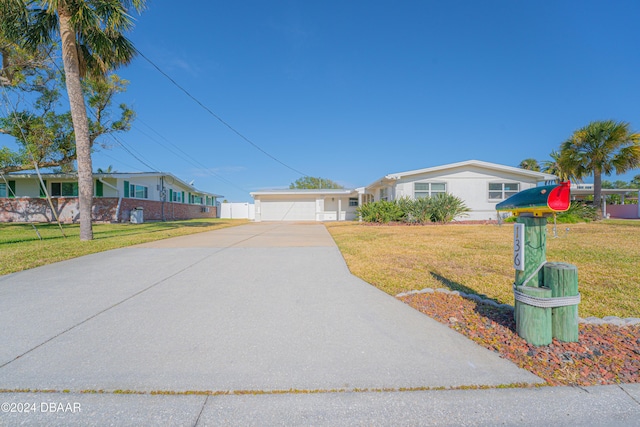 ranch-style home with a garage and a front lawn