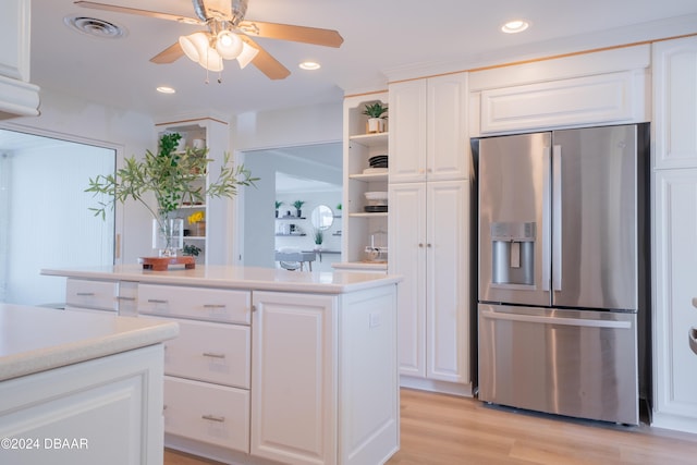 kitchen featuring ceiling fan, a kitchen island, light hardwood / wood-style flooring, stainless steel refrigerator with ice dispenser, and white cabinets