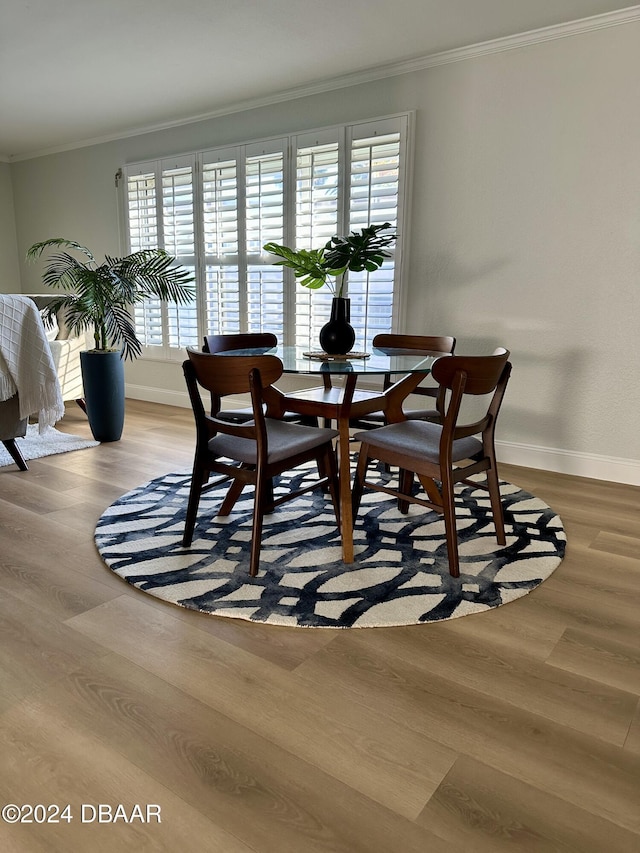 dining area with wood-type flooring and crown molding