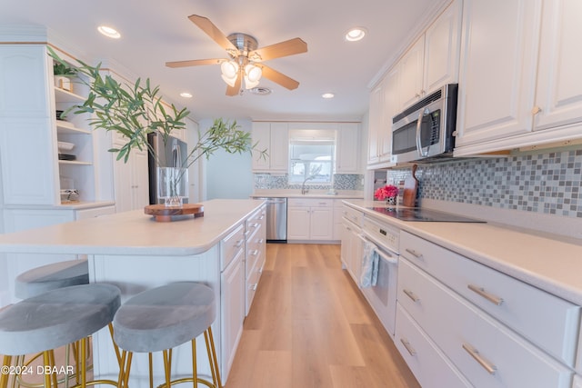 kitchen with white cabinets, a kitchen island, and stainless steel appliances