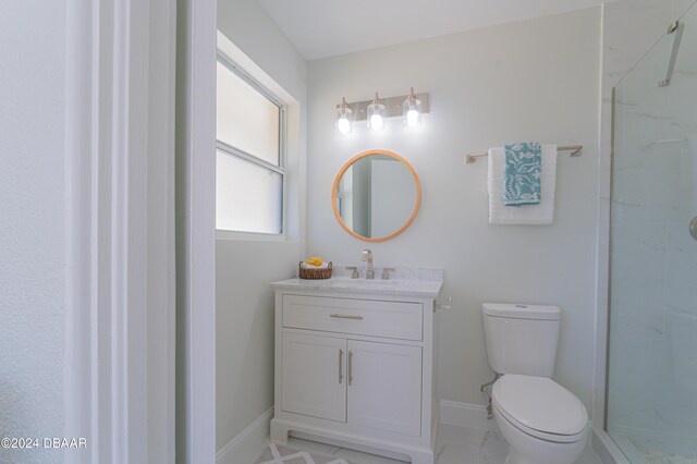 bathroom featuring vanity, toilet, and a shower with door