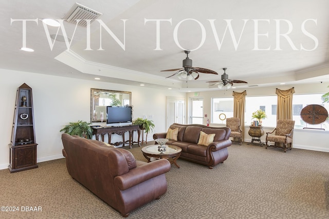 carpeted living room featuring ornamental molding, a raised ceiling, ceiling fan, and a healthy amount of sunlight