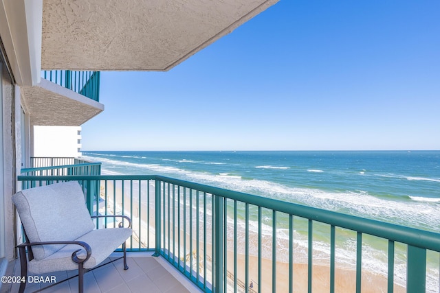 balcony featuring a water view and a beach view