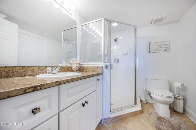 bathroom featuring tile patterned floors, vanity, toilet, and walk in shower