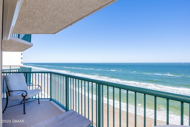 balcony with a water view and a beach view