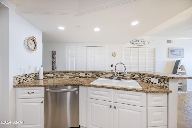 kitchen featuring dishwasher, sink, kitchen peninsula, dark stone counters, and white cabinets