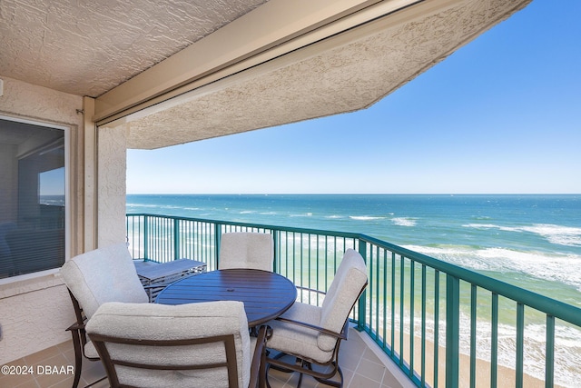 balcony with a water view and a beach view