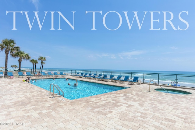 view of pool featuring a community hot tub, a water view, and a patio