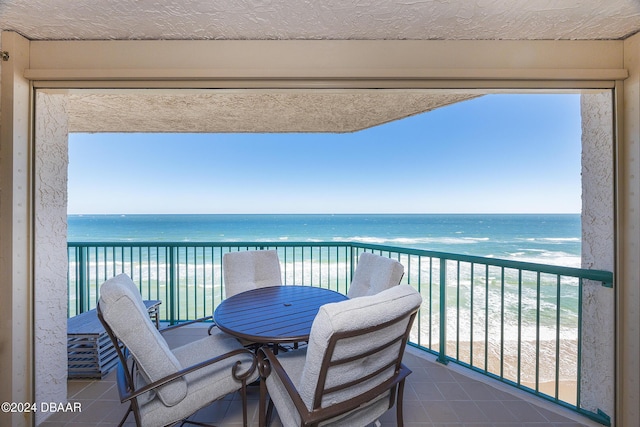 balcony featuring a water view and a beach view