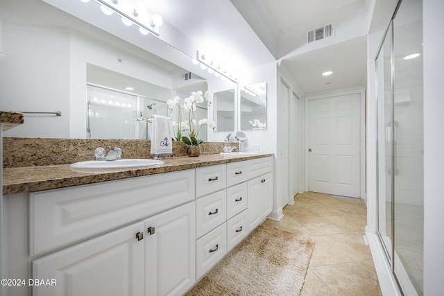 bathroom with tile patterned flooring, vanity, ornamental molding, and walk in shower