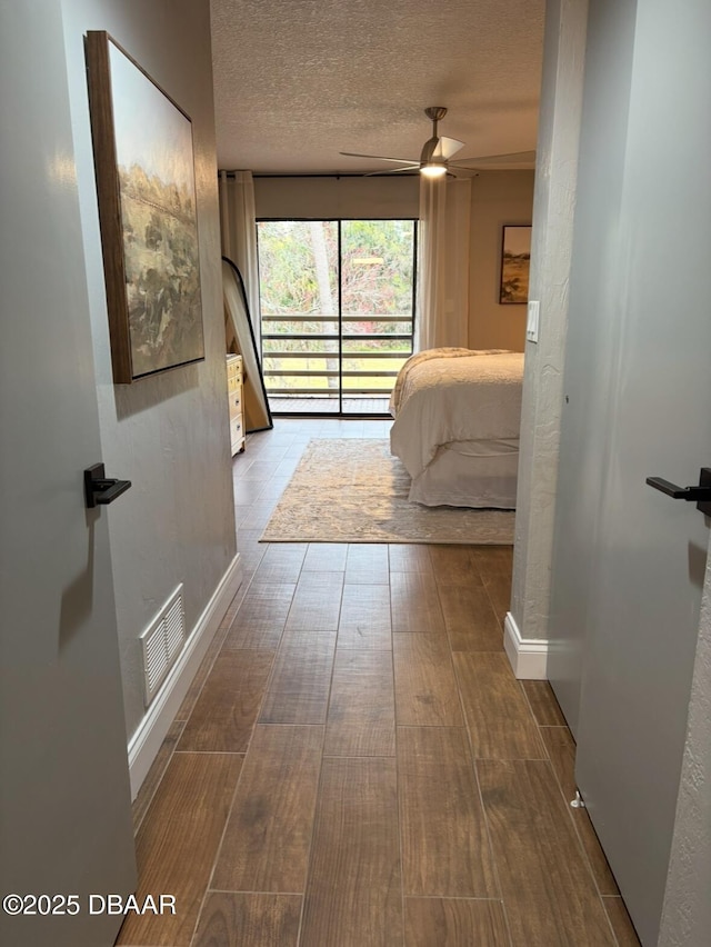 unfurnished bedroom featuring ceiling fan, access to exterior, a textured ceiling, and light hardwood / wood-style flooring