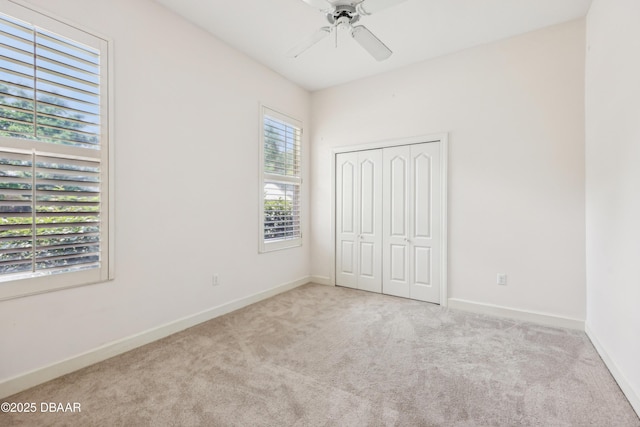 unfurnished bedroom with carpet floors, baseboards, ceiling fan, and a closet