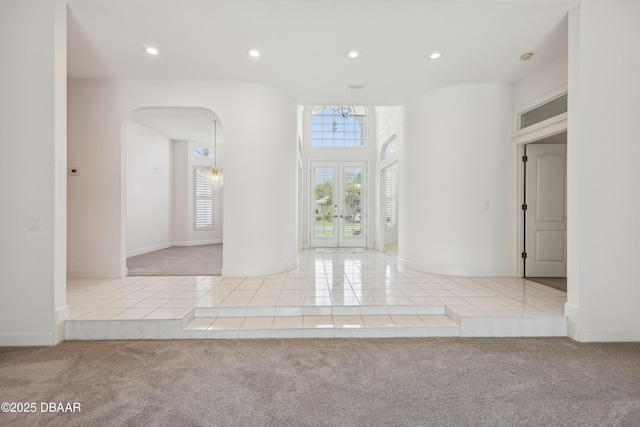 interior space with arched walkways, tile patterned flooring, french doors, and recessed lighting