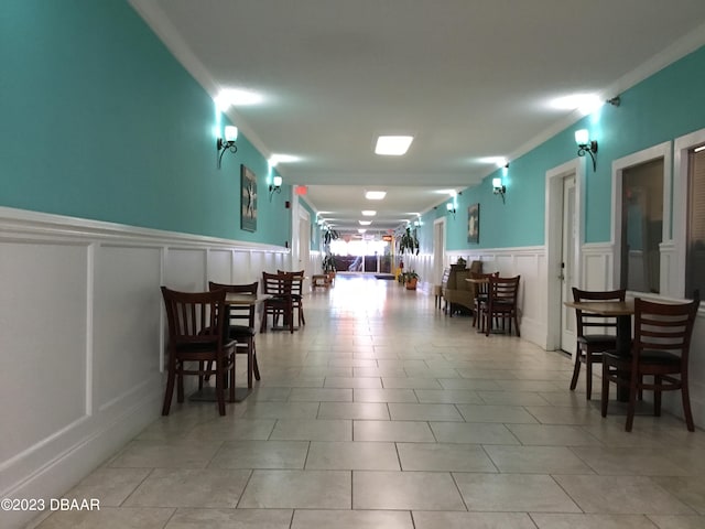 dining space with light tile patterned floors and ornamental molding