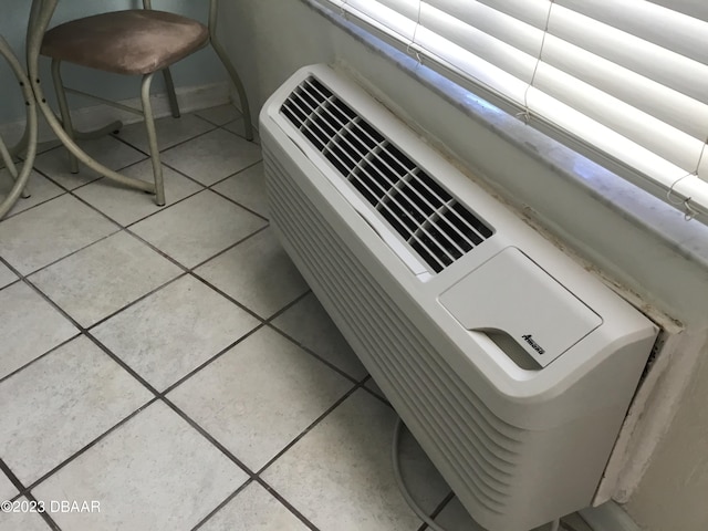 interior details with a wall mounted AC and tile patterned flooring