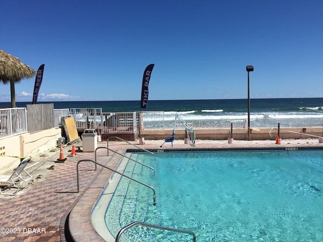 view of swimming pool featuring a water view