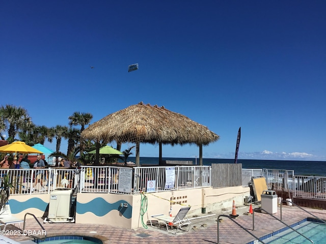 view of swimming pool featuring a water view, a patio area, and a gazebo