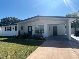 view of front of home with a front yard and a carport