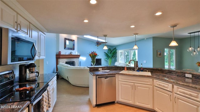 kitchen featuring ceiling fan, sink, pendant lighting, a fireplace, and appliances with stainless steel finishes