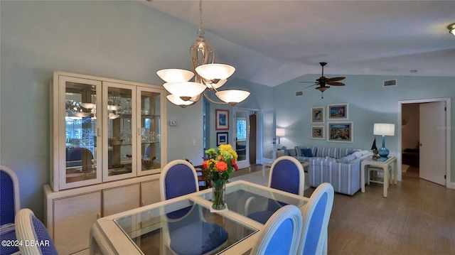 dining area featuring ceiling fan with notable chandelier, dark hardwood / wood-style flooring, and lofted ceiling