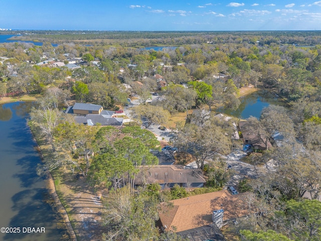 birds eye view of property with a water view and a wooded view