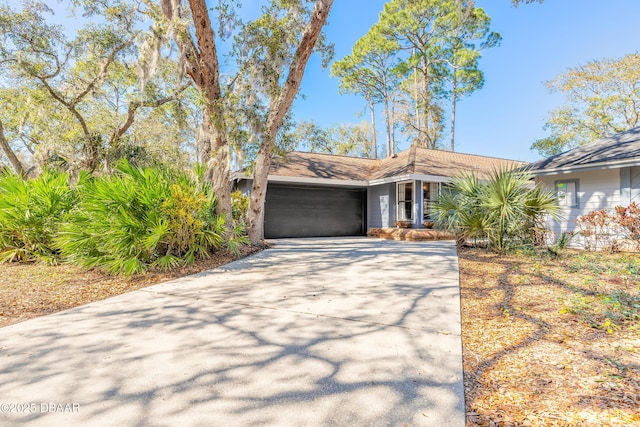 mid-century inspired home featuring an attached garage and driveway