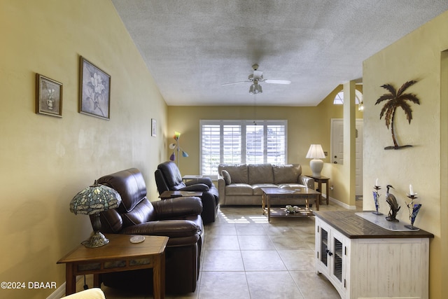 living room with ceiling fan, light tile patterned floors, and a textured ceiling