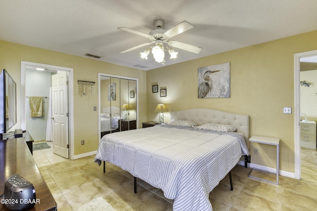 bedroom featuring light tile patterned floors, a textured ceiling, a closet, and ceiling fan