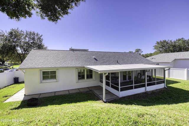 back of property with a sunroom and a yard