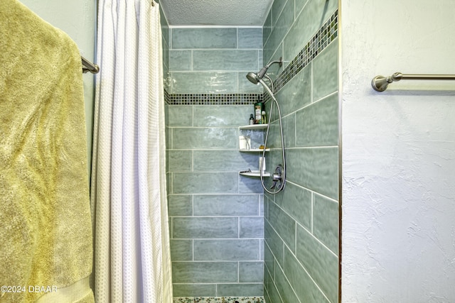 bathroom featuring a textured ceiling and curtained shower