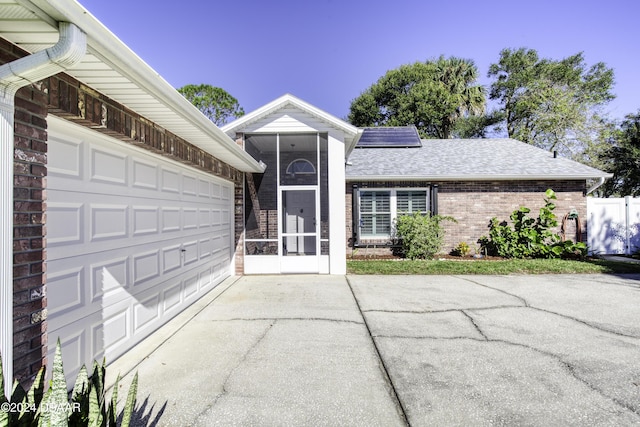 exterior space featuring solar panels and a garage