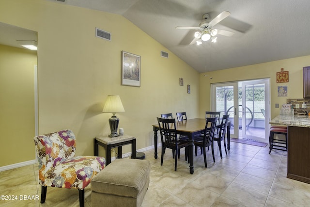 dining room with ceiling fan, light tile patterned flooring, and lofted ceiling