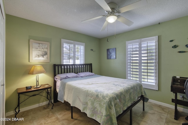 tiled bedroom featuring a textured ceiling and ceiling fan