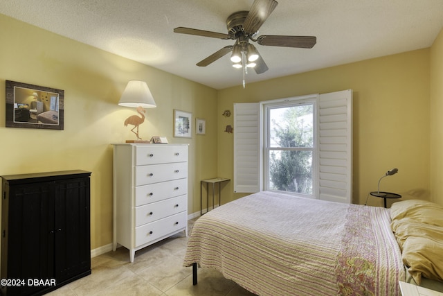 bedroom featuring a textured ceiling, ceiling fan, and light tile patterned flooring