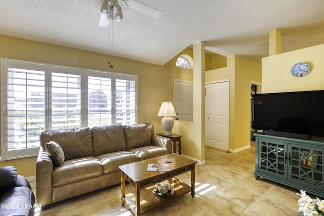 living room featuring ceiling fan, light tile patterned floors, and a textured ceiling