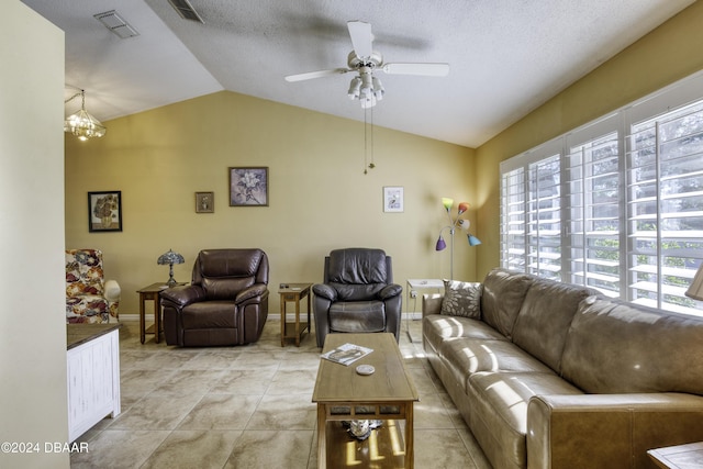 tiled living room with a textured ceiling, ceiling fan with notable chandelier, and lofted ceiling