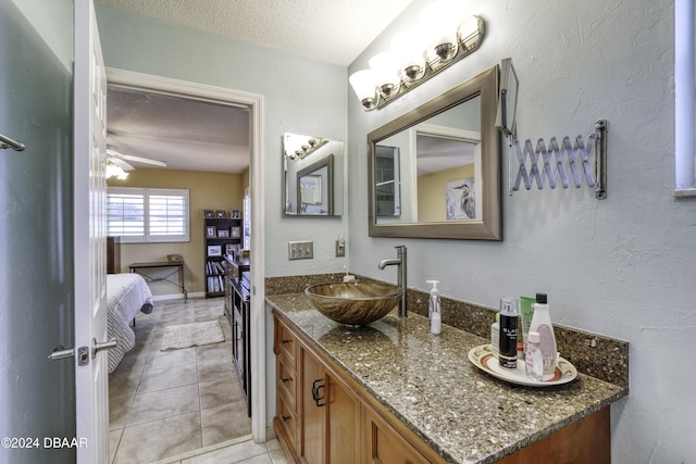 bathroom featuring tile patterned flooring, vanity, a textured ceiling, and ceiling fan