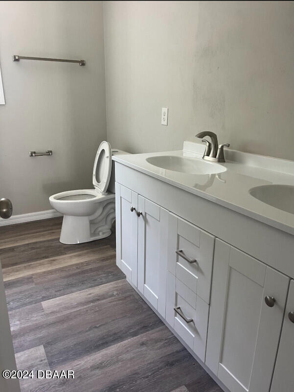 bathroom featuring toilet, hardwood / wood-style flooring, and vanity