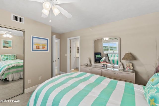 bedroom featuring a closet, light colored carpet, and ceiling fan