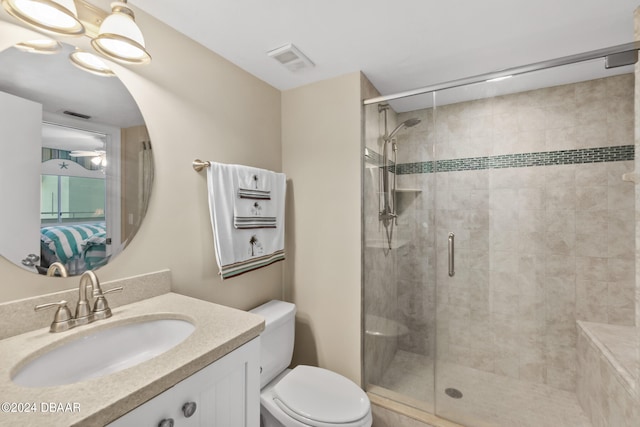 bathroom with a shower with shower door, vanity, and toilet